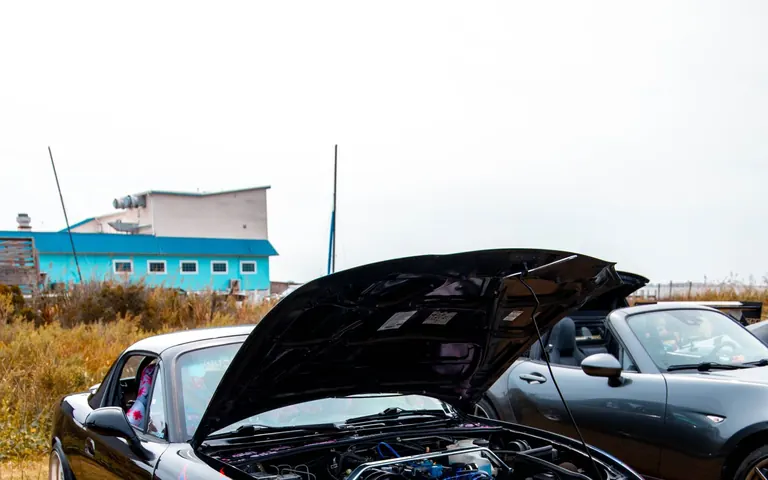 Modified Japanese performance car with hood open showing the engine bay